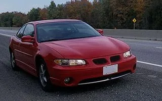 Red coupe driving on a highway